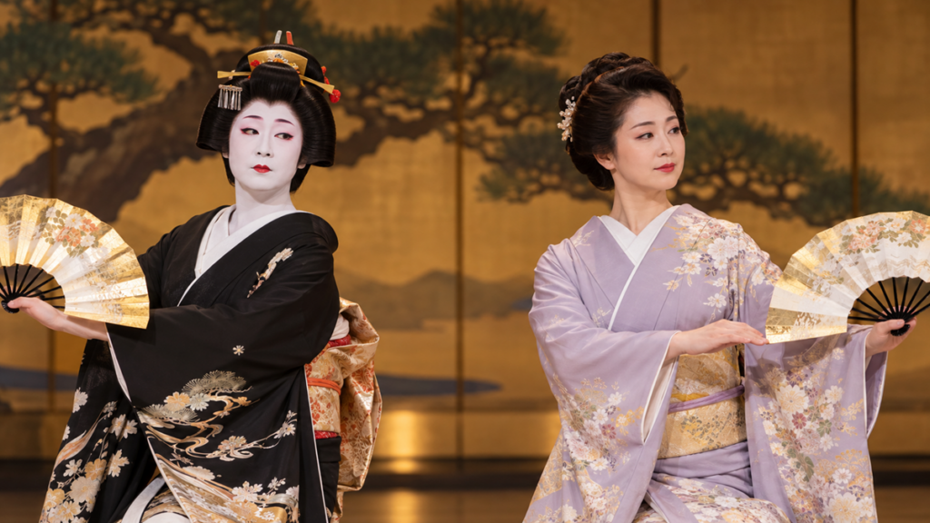 日本舞踊の舞台メイクを比較。左は白塗り化粧とかつら姿、右は自髪と自然な舞台化粧で、着物姿の女性2人が扇子を持って踊る様子。